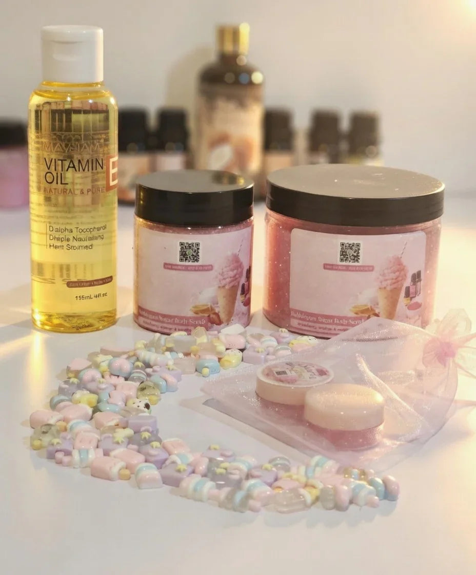 Bubble gum body scrub jars, vitamin E oil, pastels beads, and small cosmetic containers on white background