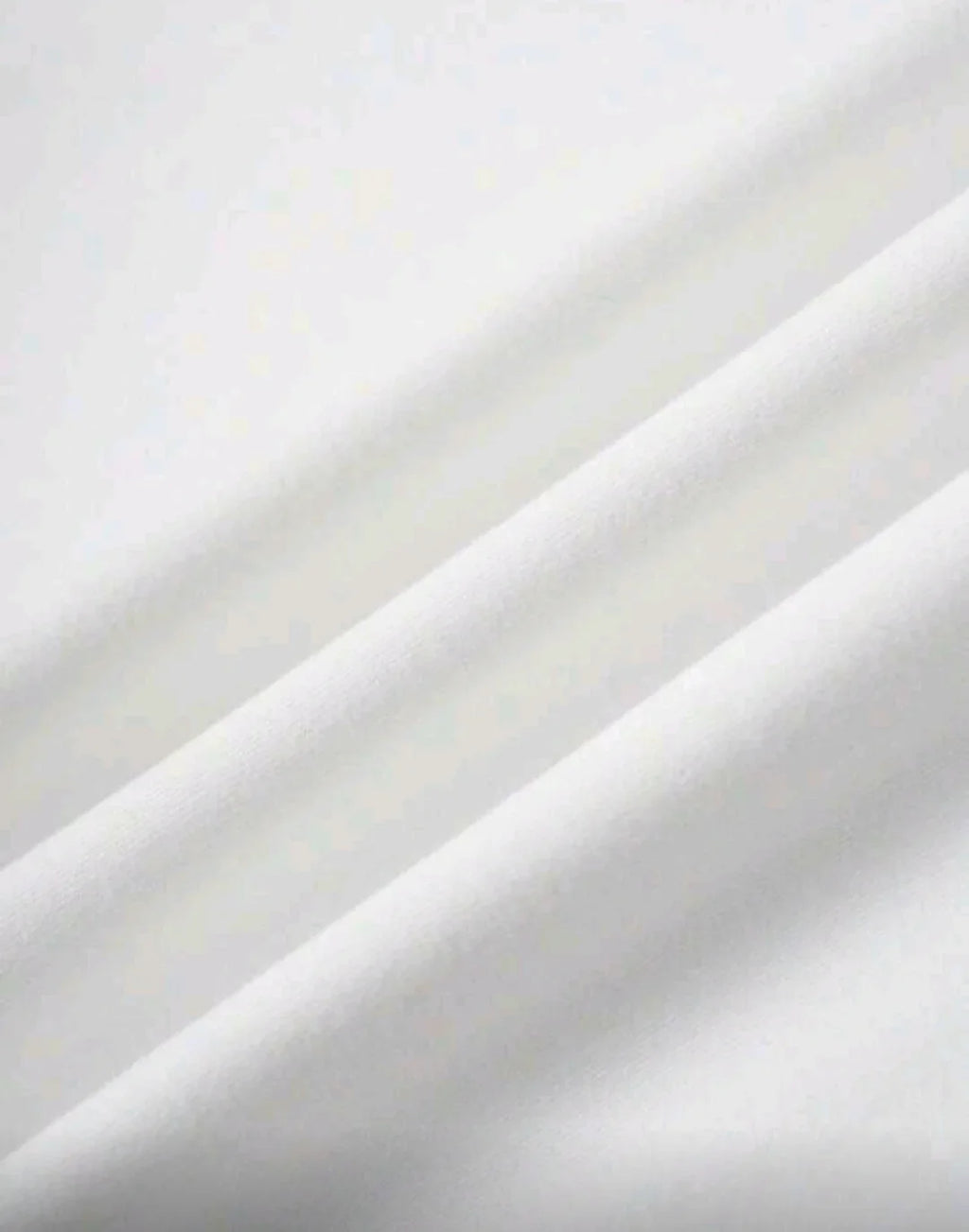 Close-up of soft, white fabric texture with smooth folds, suitable for skincare or spa use.