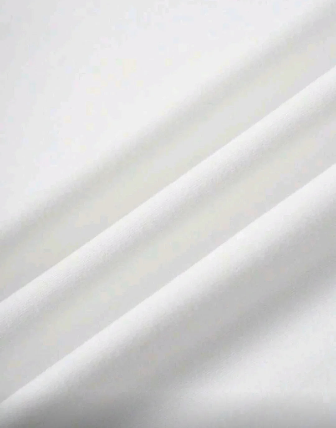 Close-up of soft, white fabric texture with smooth folds, suitable for skincare or spa use.