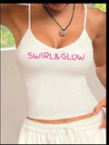 Woman in white tank top with pink SWIRL&GLOW text, casual loungewear, indoor setting