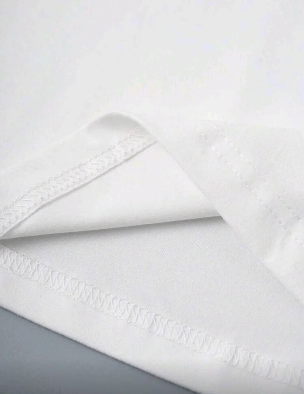 Close-up of white fabric with neat seam stitching, soft texture, clothing material detail