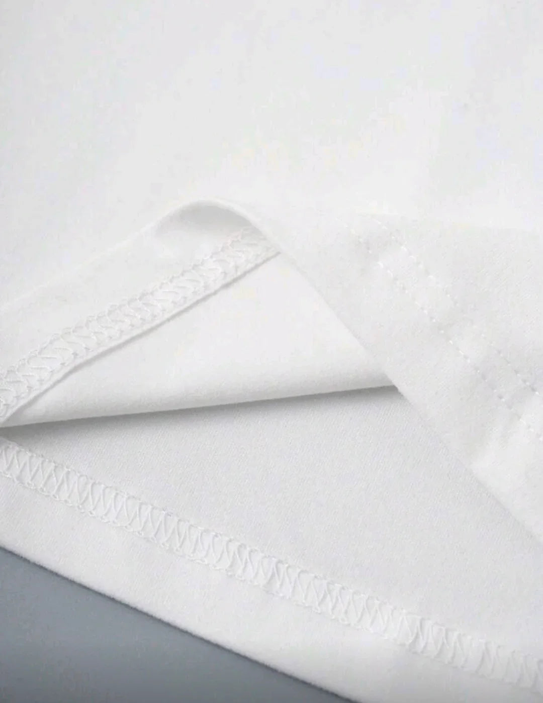 Close-up of white fabric with neat seam stitching, soft texture, clothing material detail