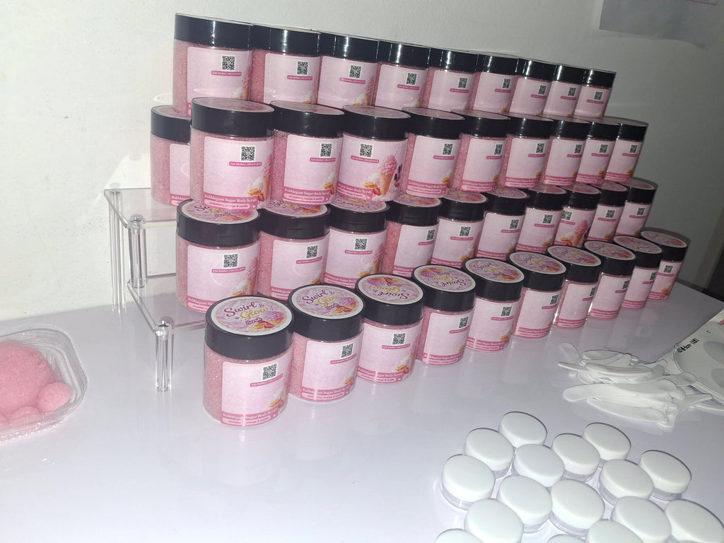 Rows of pink bubble gum body scrub jars with black lids on display table